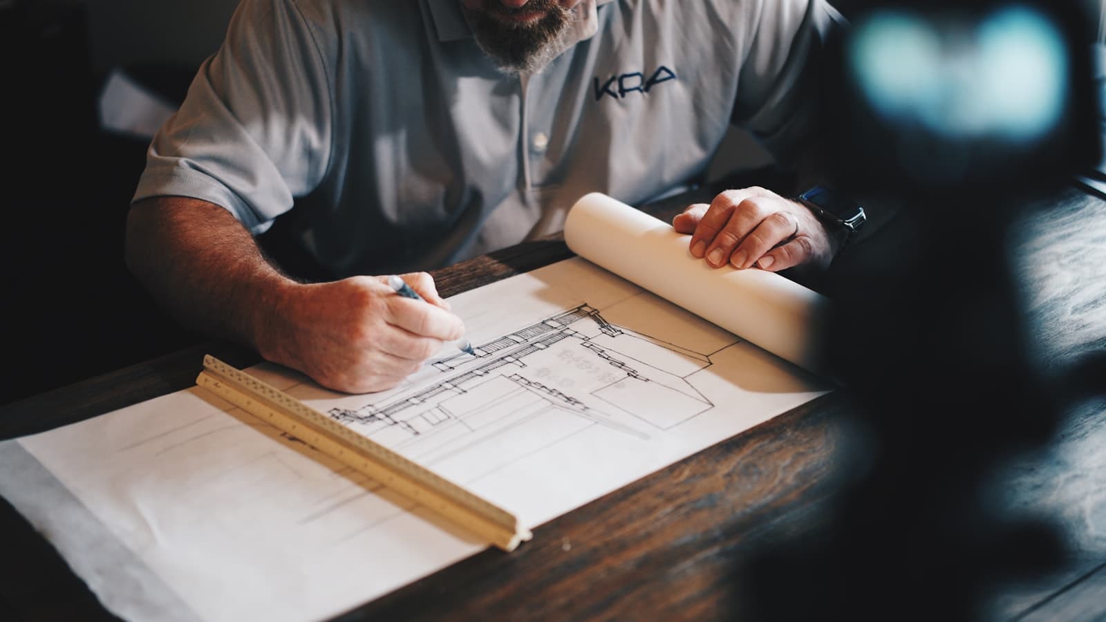 Engineer marking a technical drawing on a workshop table