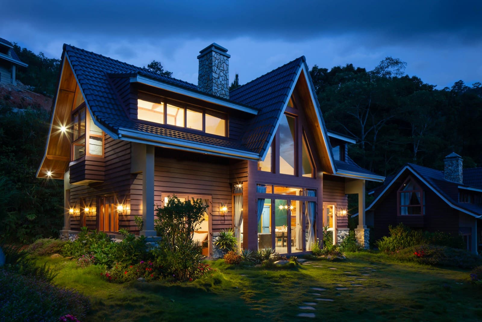 House at dusk with rooms lit — demonstration of heat staying in the fabric