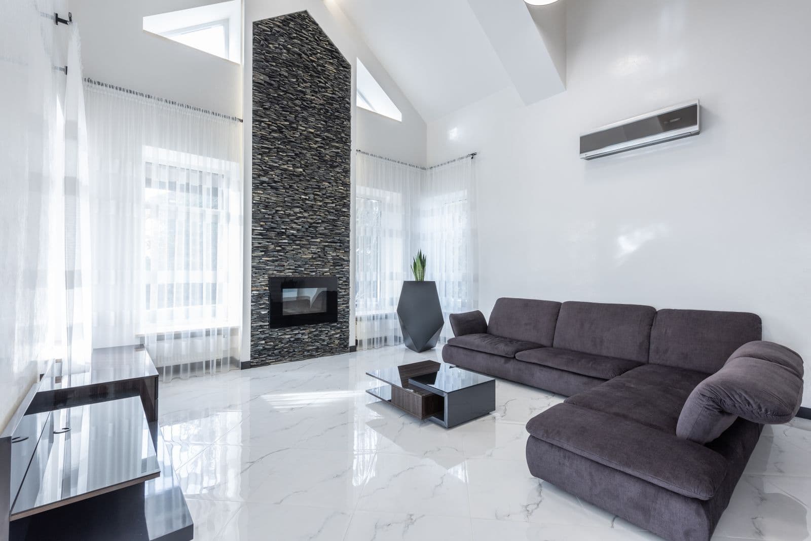 Finished living room with a wall-mounted climate unit high on the wall